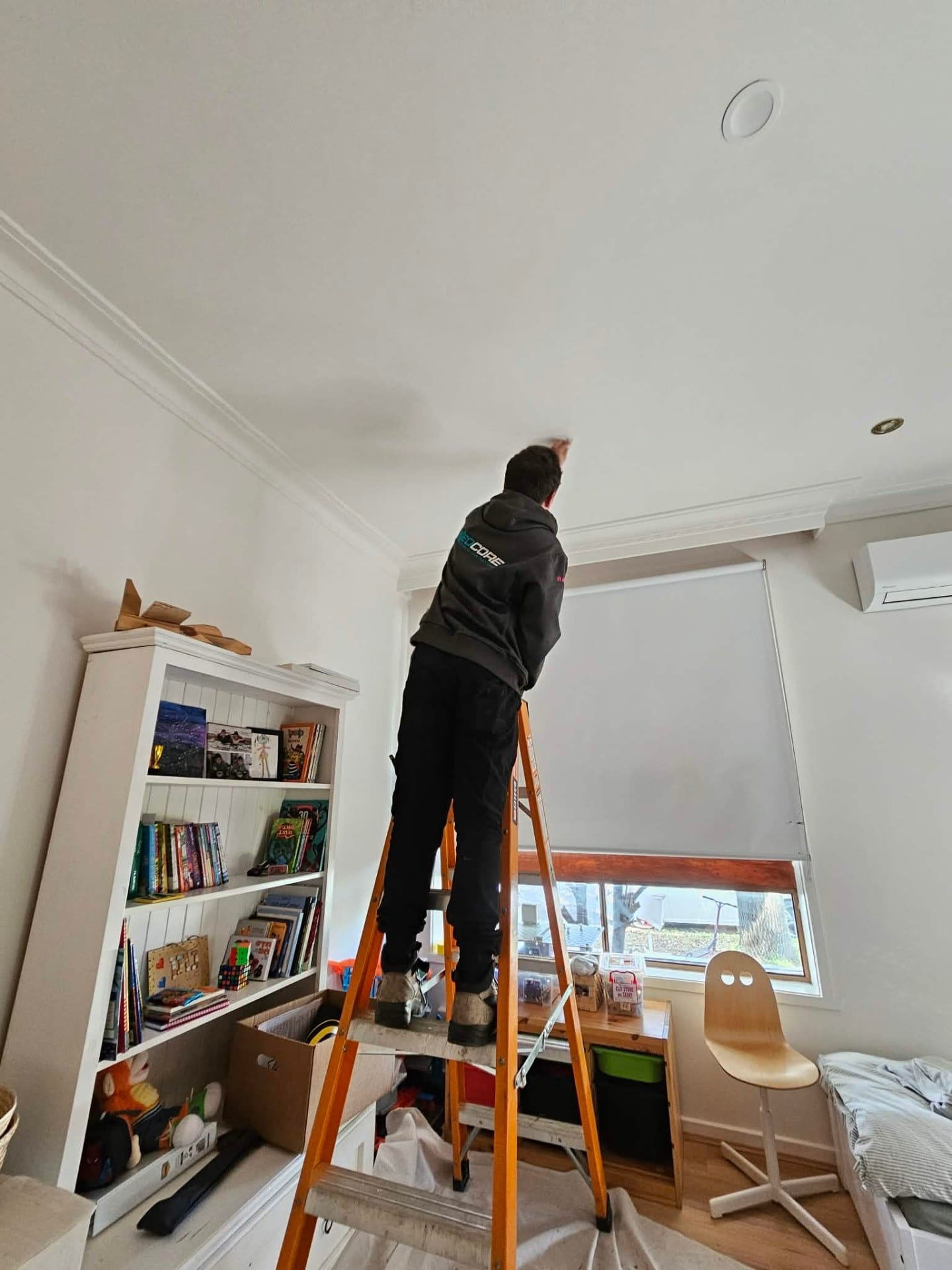 Neocore electrician installing ceiling downlights in a Melbourne home